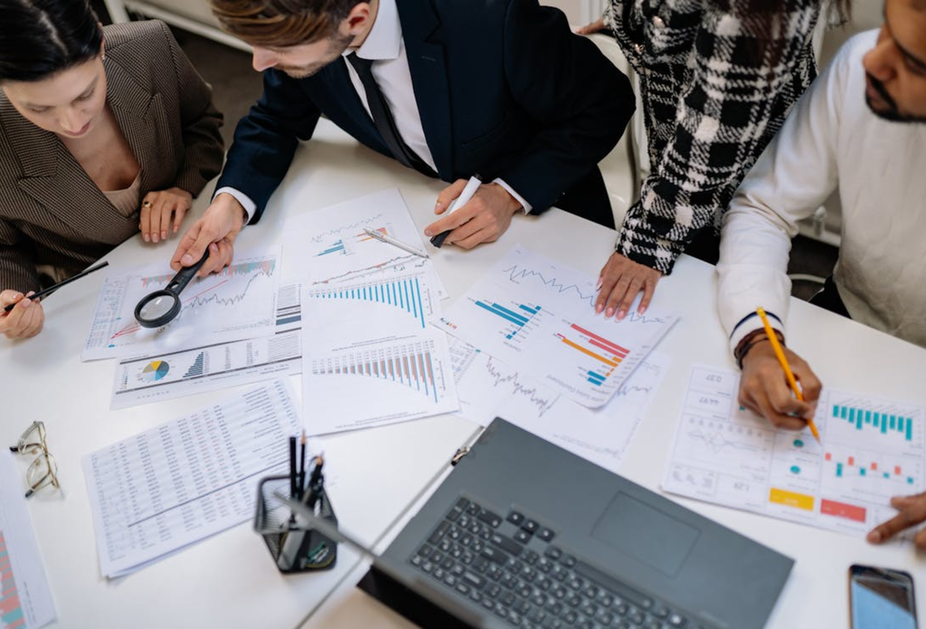 High-performing B2B marketing teams analyzing campaign data, charts, and performance reports during a strategy meeting