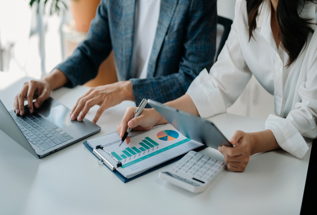 wo professionals analyzing data charts and digital reports to build scalable B2B marketing systems for long-term pipeline growth.